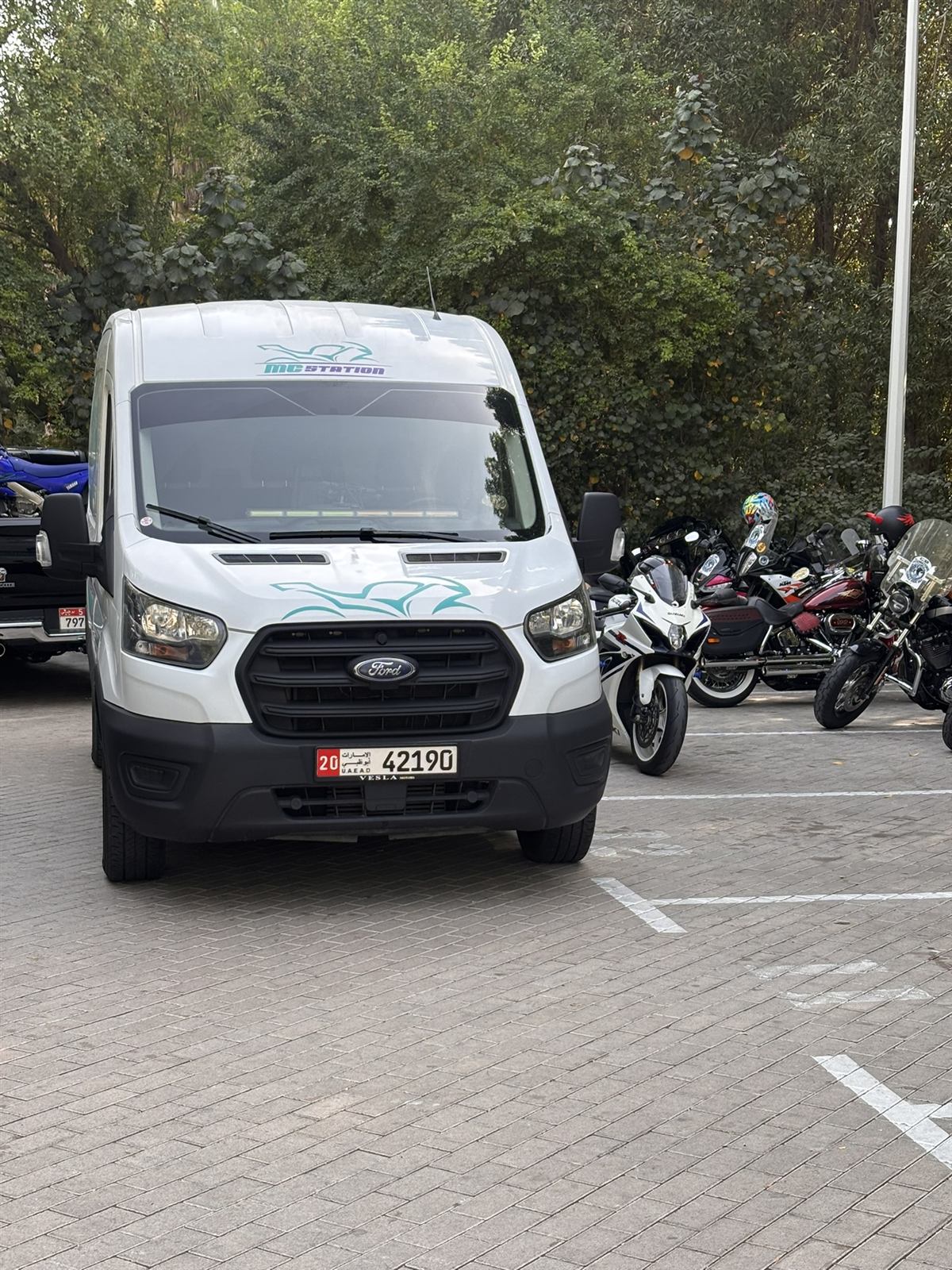 MC Station van at a motorcycle event alongside riders' bikes