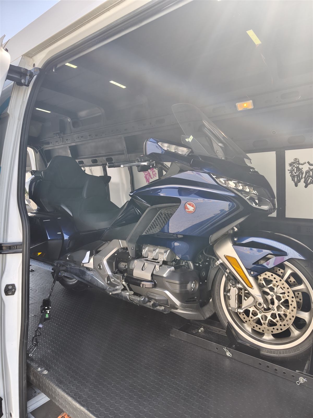 A touring motorcycle loaded in the van, ready for its appointment