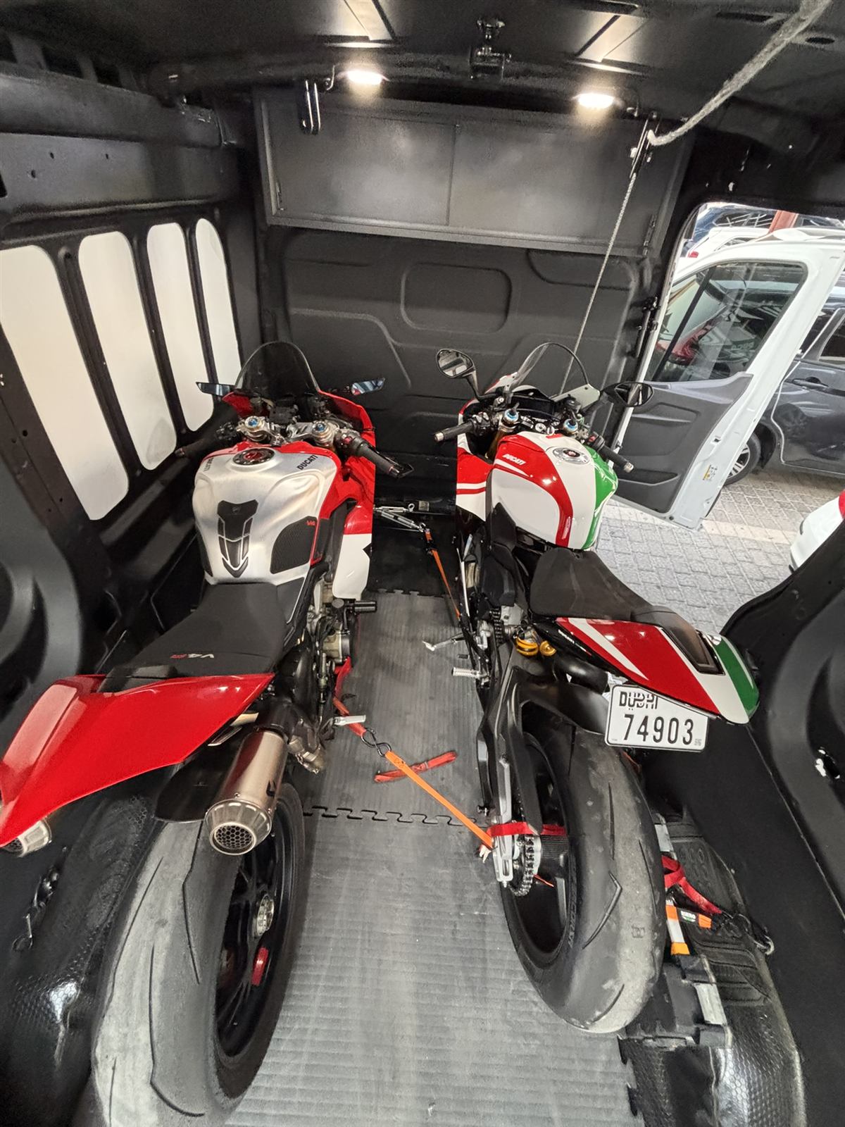 Two Ducati superbikes strapped side by side in the van