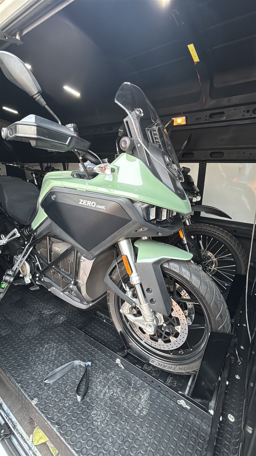 An electric adventure motorcycle secured inside the van for an agency delivery